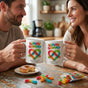 A loving couple smiling while drinking coffee from their matching unique relationship mugs at a kitchen counter.