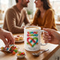 Two people holding matching matching ORCA couple mugs with a gummy worm heart design.