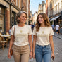 50-year-old mom and adult daughter walking city street in matching grace kindness tees